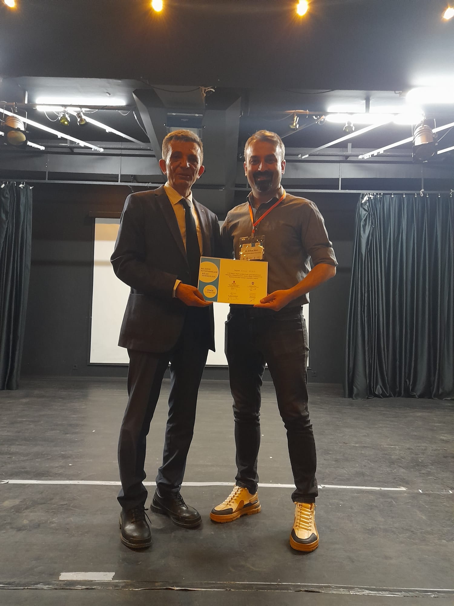 Erdinç Alaca'nın katılımcı belgesi alırken çekilmiş fotoğrafı