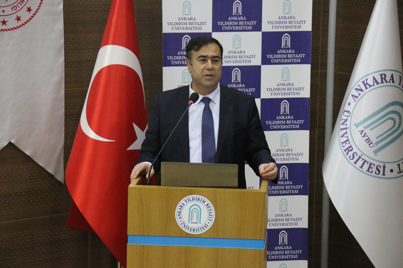 A photo of our Faculty Dean, Prof. Dr. Hüseyin TUTAR, speaking at the podium.