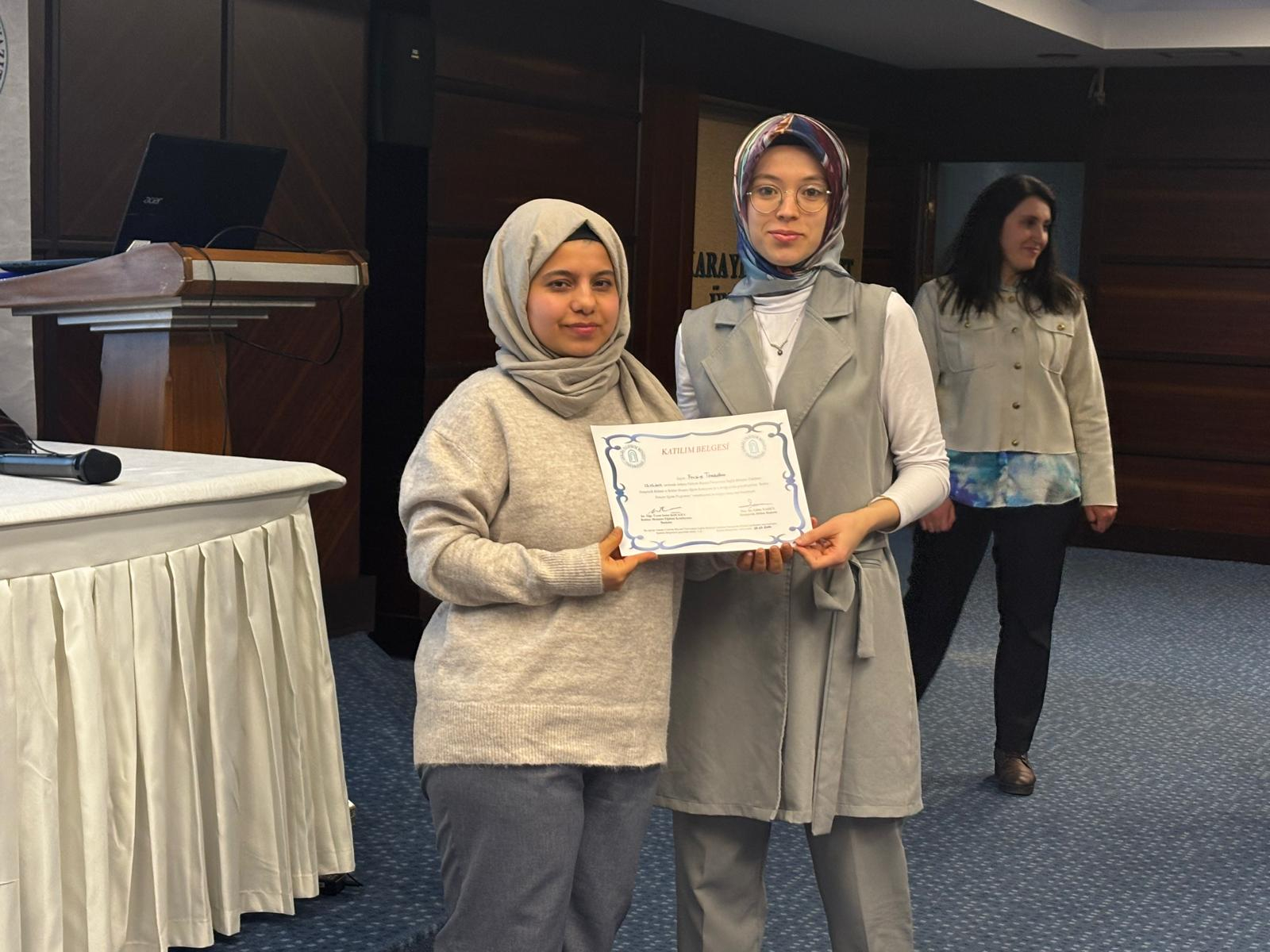 Komisyon üyesinin rehber hemşireye katılım belgesi verirken çekilen fotograf