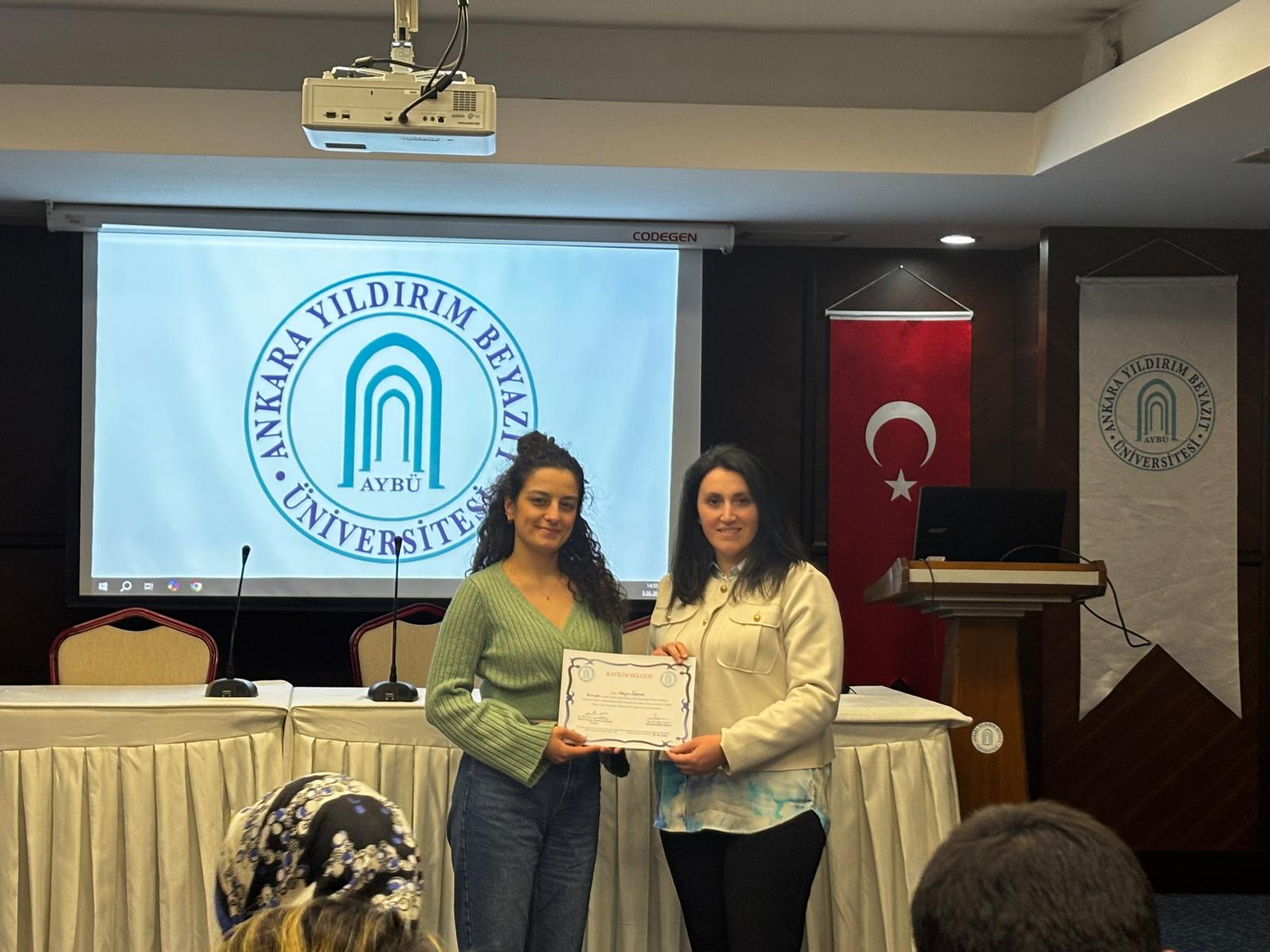 Komisyon üyesinin rehber hemşireye katılım belgesi verirken çekilen fotograf 2