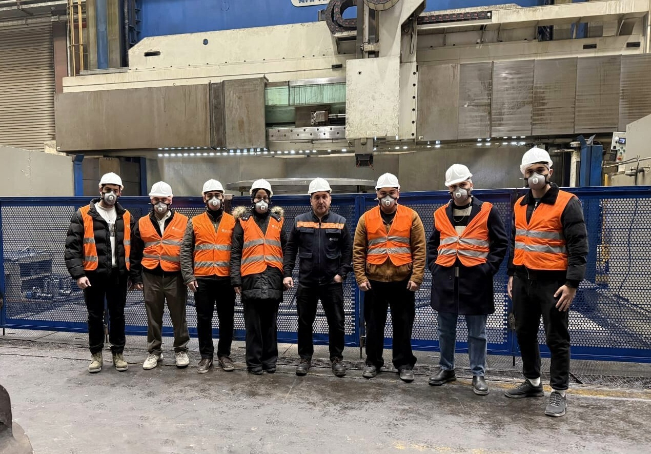 Bölümümüz Öğretim Üyelerinden Prof. Dr. Adem Çiçek ve Arş. Gör. Eda Nur İris'in AKDAŞ Döküm fabrikasında bulunan freze tezgahı önünde teknik geziye katılan öğrencilerle çekindikleri toplu fotoğraf