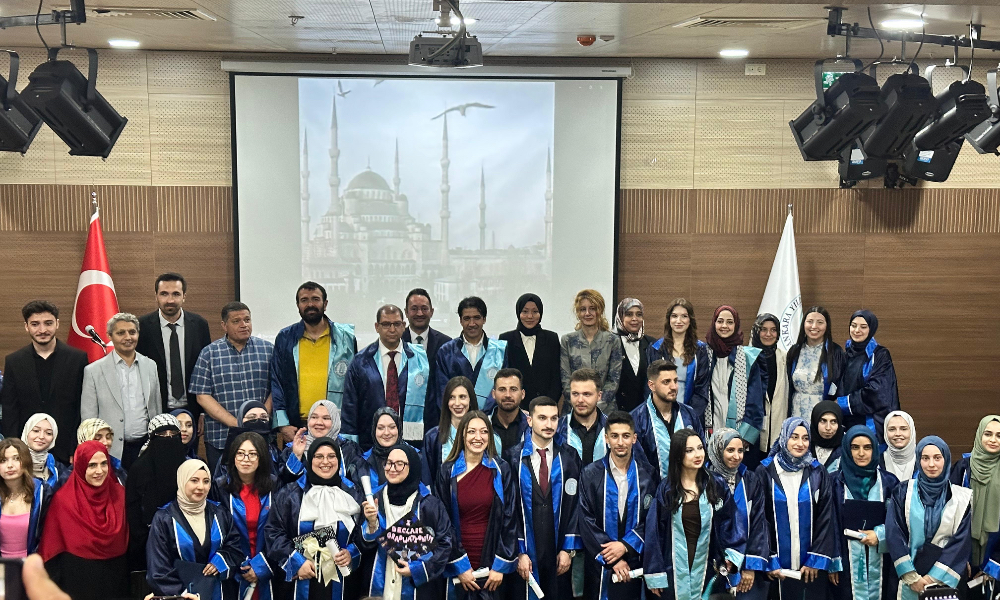 Group photo of our graduates and faculty members taken on stage.